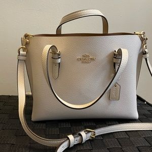 Cream Coach crossbody bag.